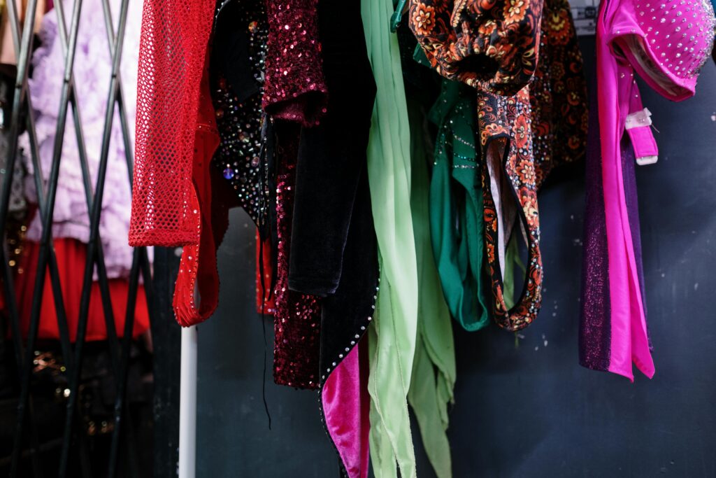 Vibrant and stylish costumes hanging in a dressing room, showcasing fashion and luxury.
